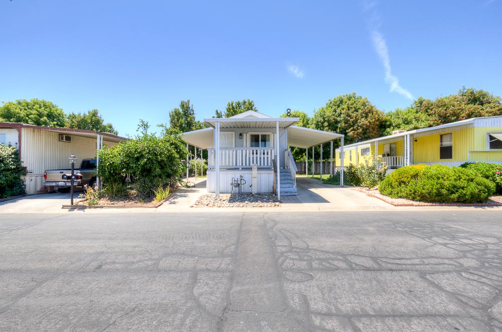 1218 East Cleveland Avenue, Unit 19 Madera, CA 93638 - Photo 18 of 18 a front view of a house with a yard and garage