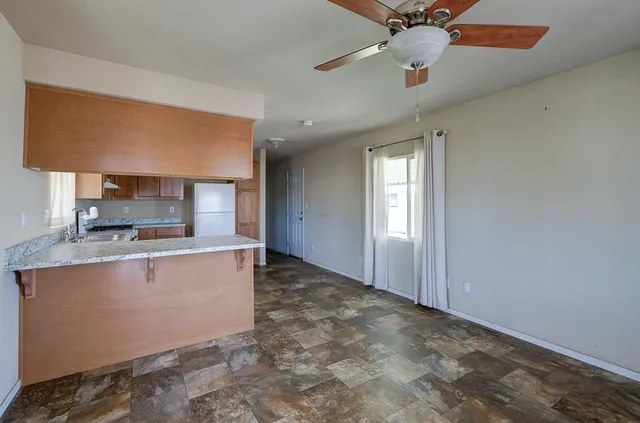 a view of kitchen with stainless steel appliances wooden floor and view living room