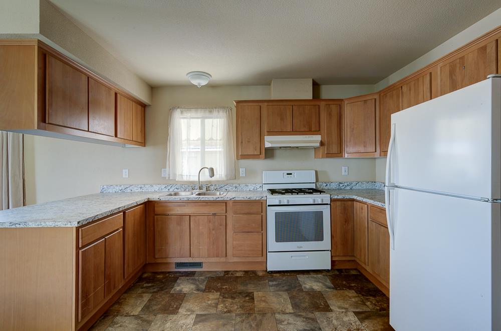 1218 East Cleveland Avenue, Unit 19 Madera, CA 93638 - Photo 10 of 18 a kitchen with stainless steel appliances granite countertop a sink stove and refrigerator