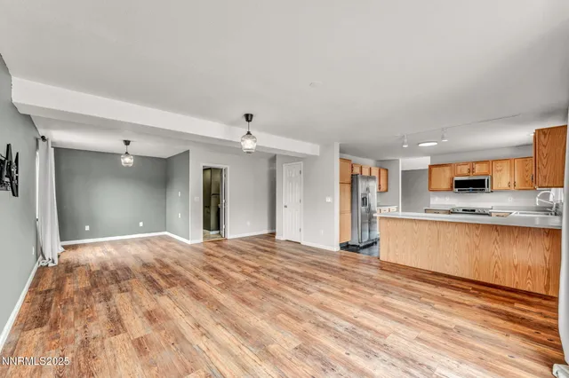 a view of a kitchen with wooden floor and a refrigerator