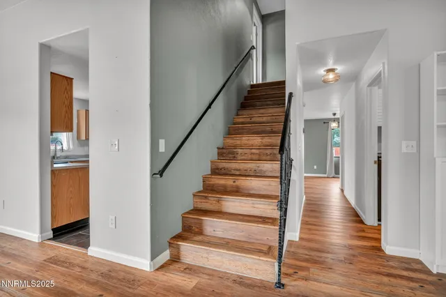 a view of a hallway with wooden floor and staircase