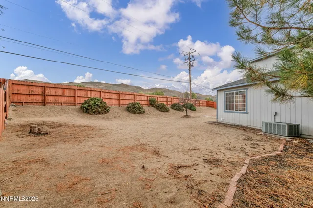 a backyard of a house with fire pit and trees