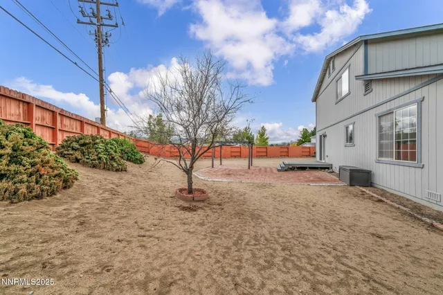 a view of a backyard with plants and wooden fence