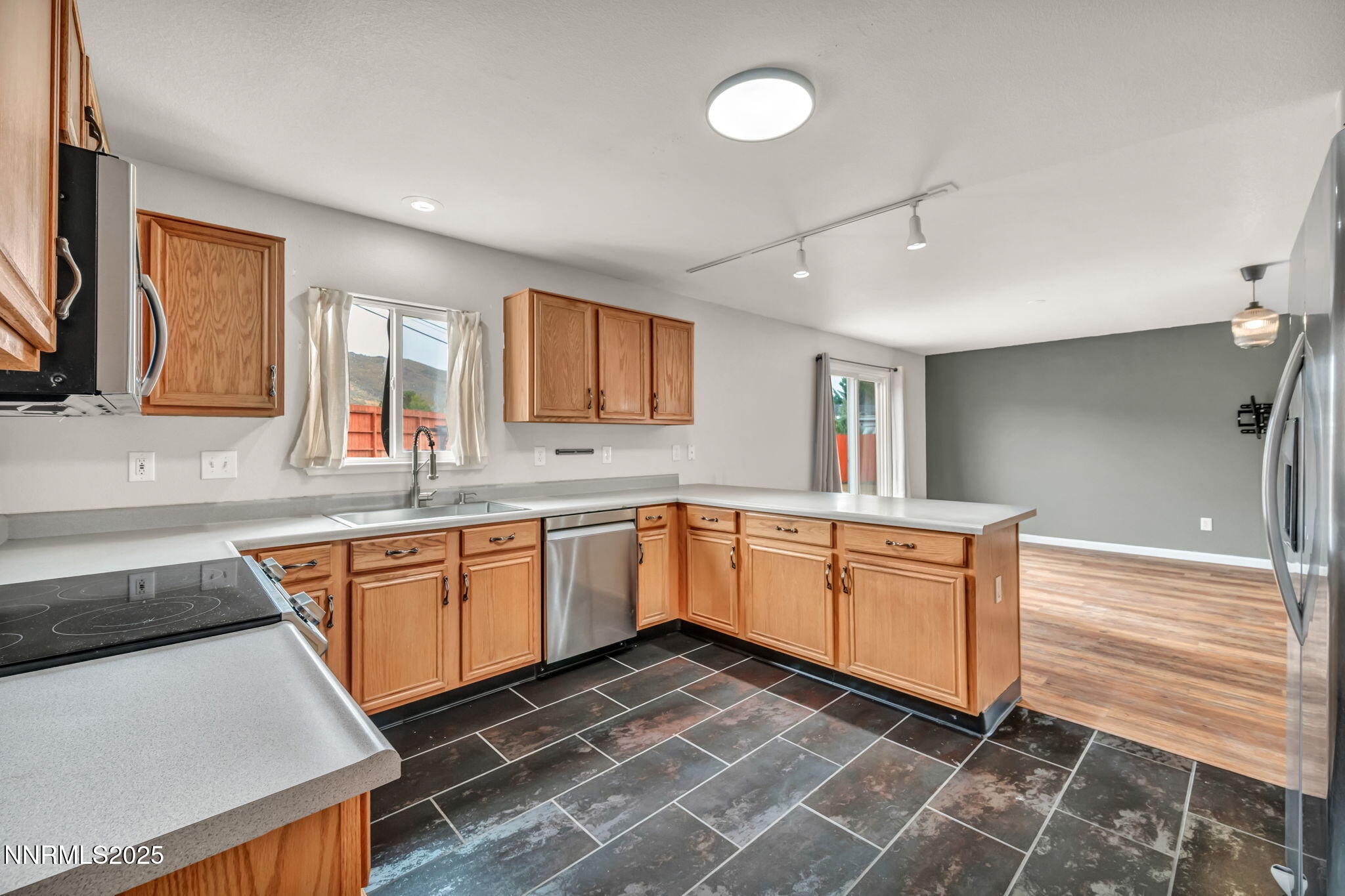 17702 Clear Springs Court Reno, NV 89508 - Photo 9 of 41 a kitchen with stainless steel appliances granite countertop a sink and dishwasher a stove top oven with wooden floor