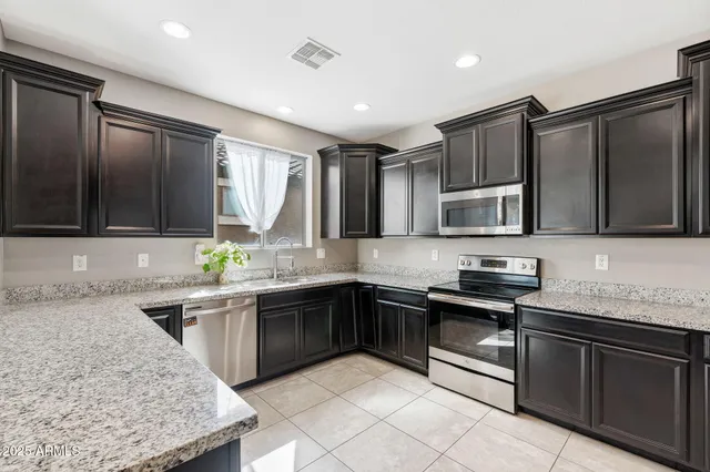 a kitchen with stainless steel appliances granite countertop a sink stove and microwave