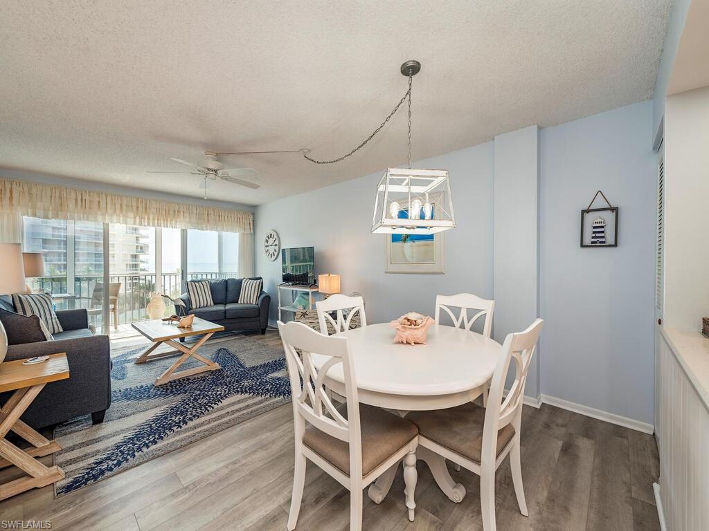 1 Bluebill Avenue, Unit 709 Naples, FL 34108 - Photo 5 of 12 a view of a dining room with furniture wooden floor and chandelier