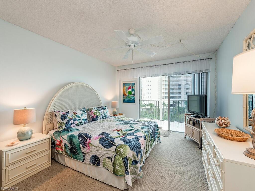 1 Bluebill Avenue, Unit 709 Naples, FL 34108 - Photo 8 of 12 a bedroom with a bed large window with table and chairs