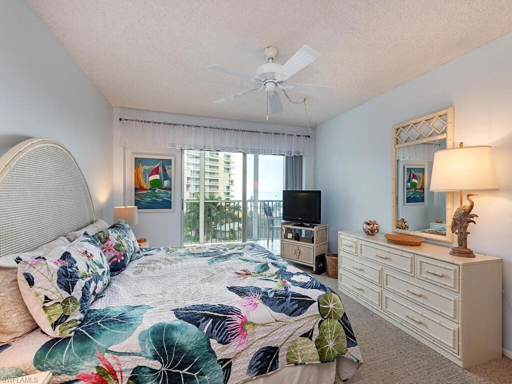 1 Bluebill Avenue, Unit 709 Naples, FL 34108 - Photo 9 of 12 a bedroom with furniture and a flat screen tv