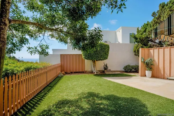 a view of a backyard with wooden fence and a bench