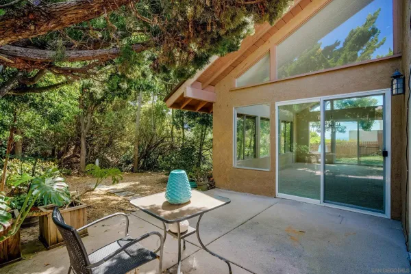a view of a chair and table in backyard of the house