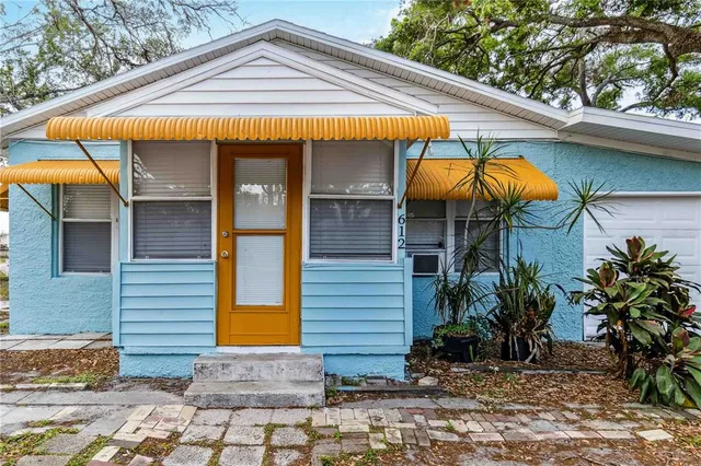 a view of a house with door and wooden bench