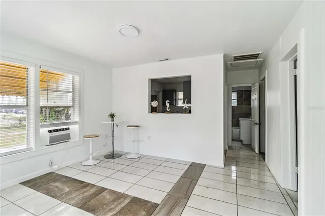 a view of a hallway with wooden floor and a living room