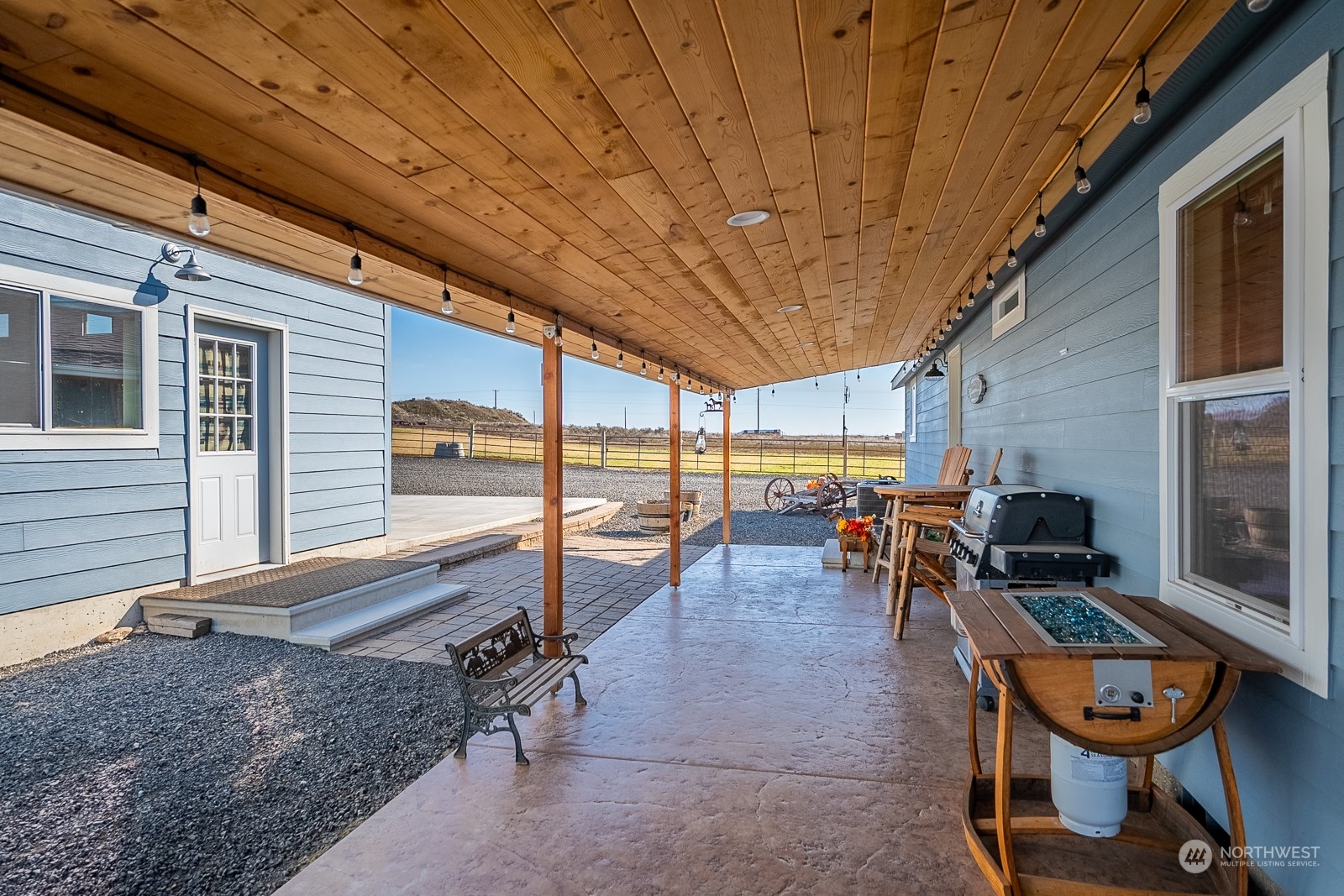 8079 Ne Road North Moses Lake, WA 98837 - Photo 6 of 26 a view of a patio with table and chairs barbeque potted plants and floor to ceiling window
