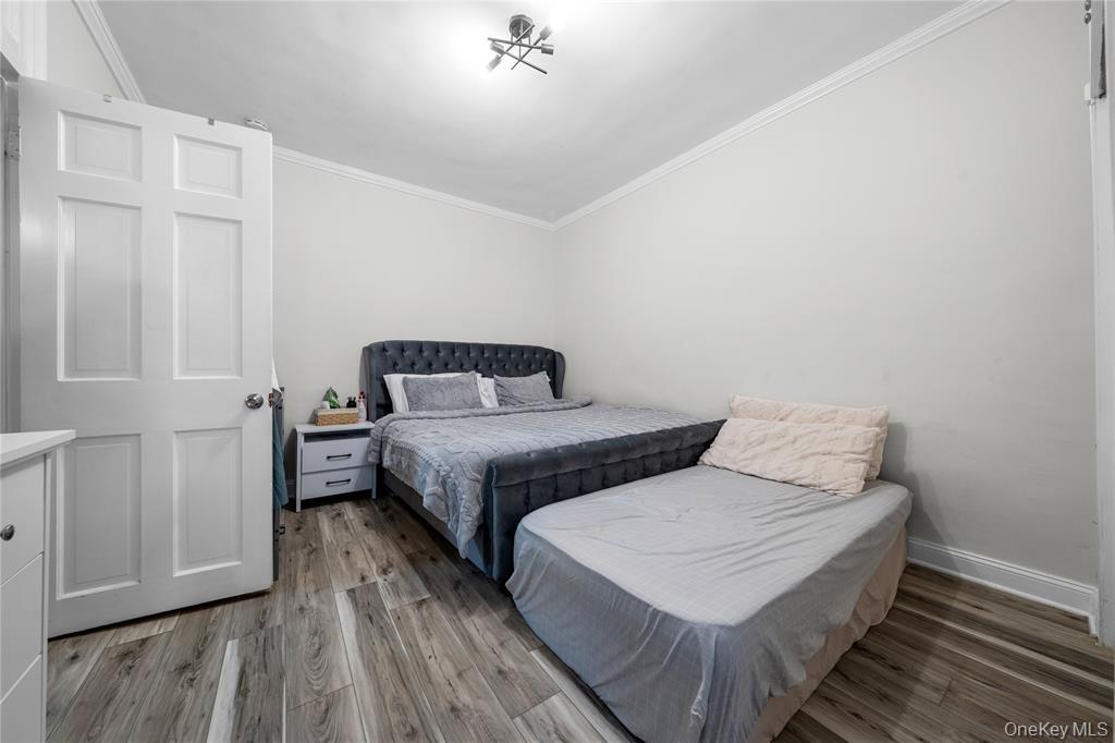 43-33 48th Street, Unit 2B Queens, NY 11104 - Photo 9 of 13 a bedroom with two beds and wooden floor