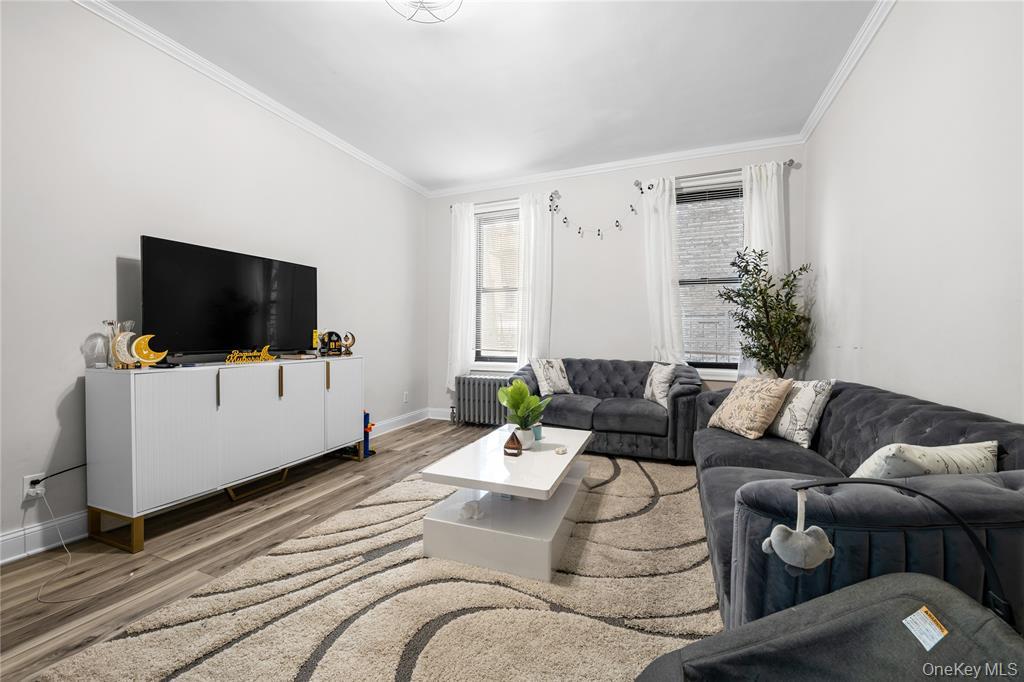 43-33 48th Street, Unit 2B Queens, NY 11104 - Photo 10 of 13 a living room with furniture and a flat screen tv