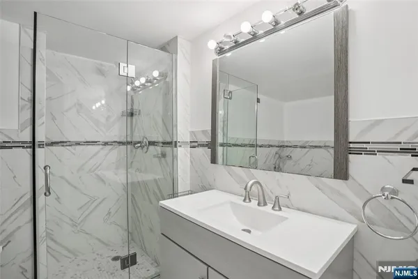 a bathroom with a sink a mirror and a shower