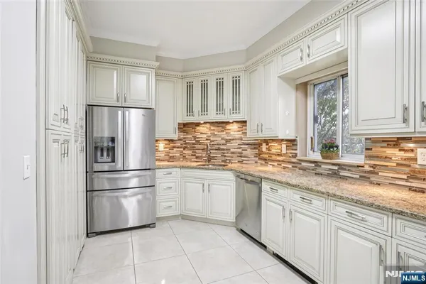 a kitchen with stainless steel appliances granite countertop a refrigerator sink and cabinets