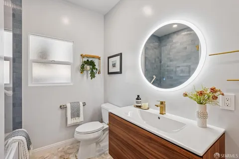 a bathroom with a sink and mirror with toilet