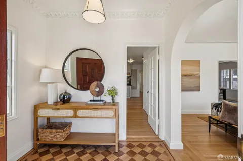 a living room with a couch and a dining table with wooden floor