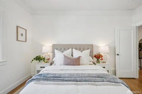 a bedroom with a bed and a painting on the wall