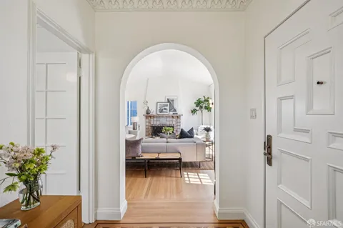 a living room with furniture a fireplace and a floor to ceiling window