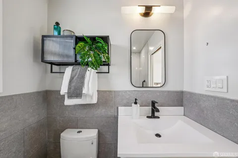 a bathroom with a sink a toilet and mirror