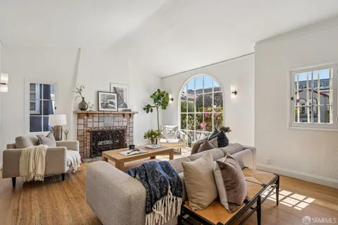 a living room with furniture chess table and a potted plant