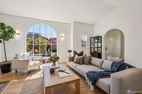 a living room with furniture a chandelier and a potted plant