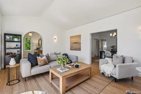 a living room with furniture a fireplace and a table