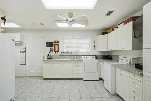 a kitchen with white cabinets and appliances