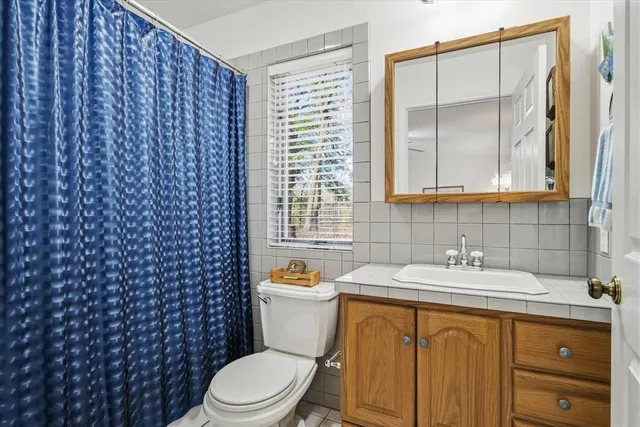 a bathroom with a granite countertop sink toilet and shower