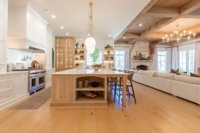 a dining hall with stainless steel appliances kitchen island granite countertop a stove and a view of living room