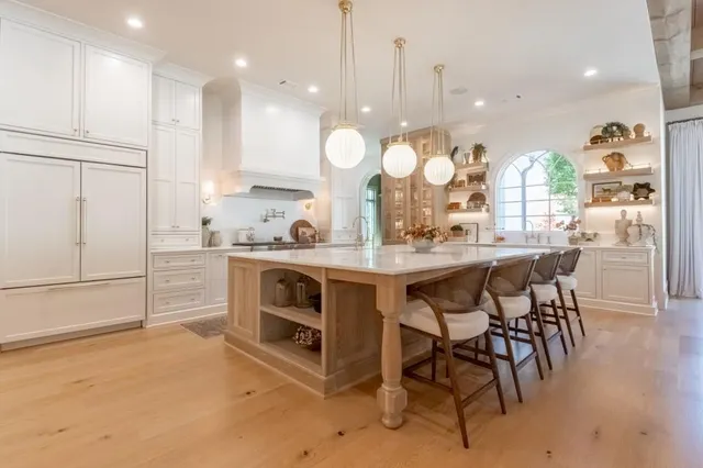 a kitchen with kitchen island a stove a table and chairs in it