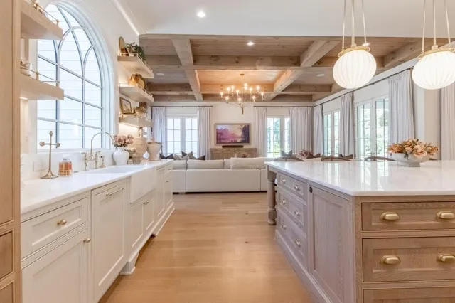 a large kitchen with a large counter space a sink and stainless steel appliances