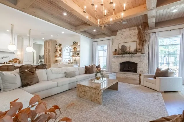 a living room with furniture a fireplace and a chandelier