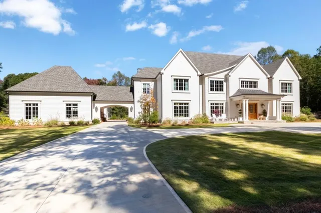 a front view of a house with a garden and yard