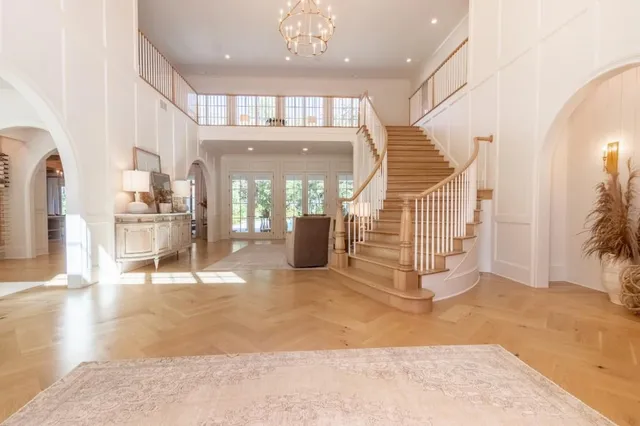 a view of a hallway with a dining table and chandelier