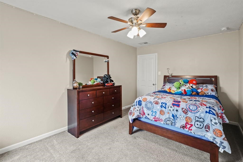6719 Path Way Court Katy, TX 77449 - Photo 30 of 35 a bedroom with a bed and a dresser in it