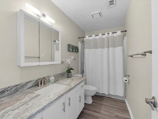 a bathroom with a granite countertop sink and a mirror
