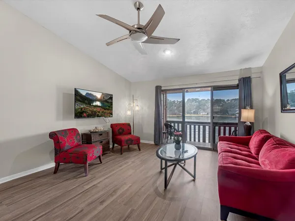 a living room with furniture a flat screen tv and a large window