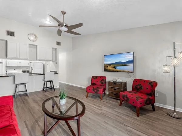 a living room with furniture and wooden floor