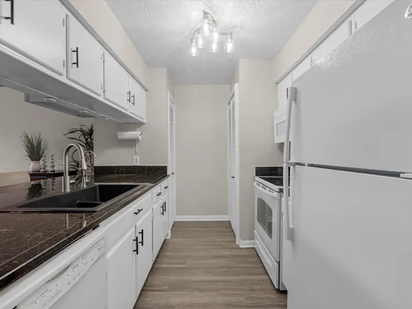 a kitchen with stainless steel appliances granite countertop a sink and a refrigerator