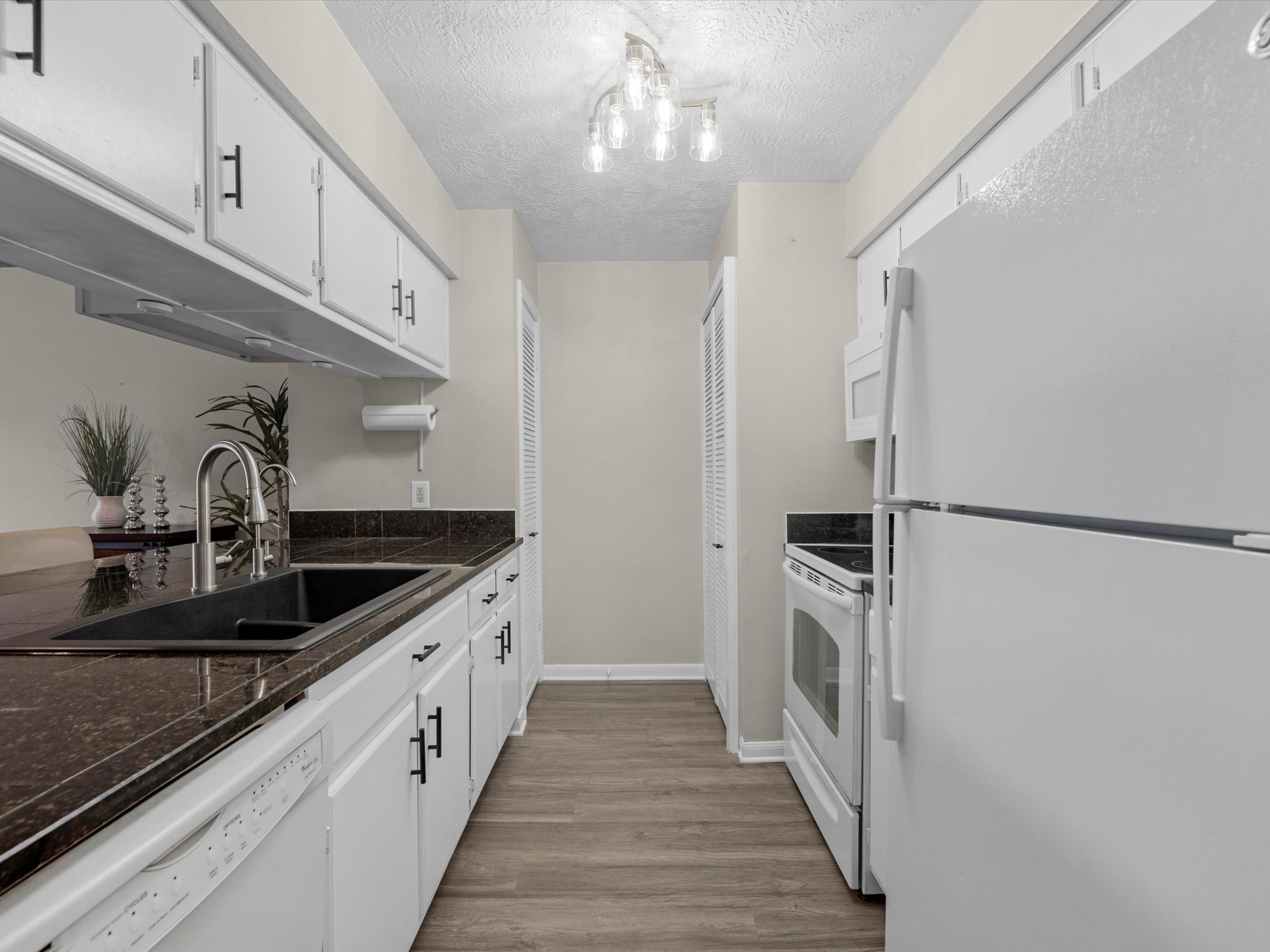 801 River Road, Unit 114F Montgomery, TX 77356 - Photo 9 of 25 a kitchen with stainless steel appliances granite countertop a sink and a refrigerator