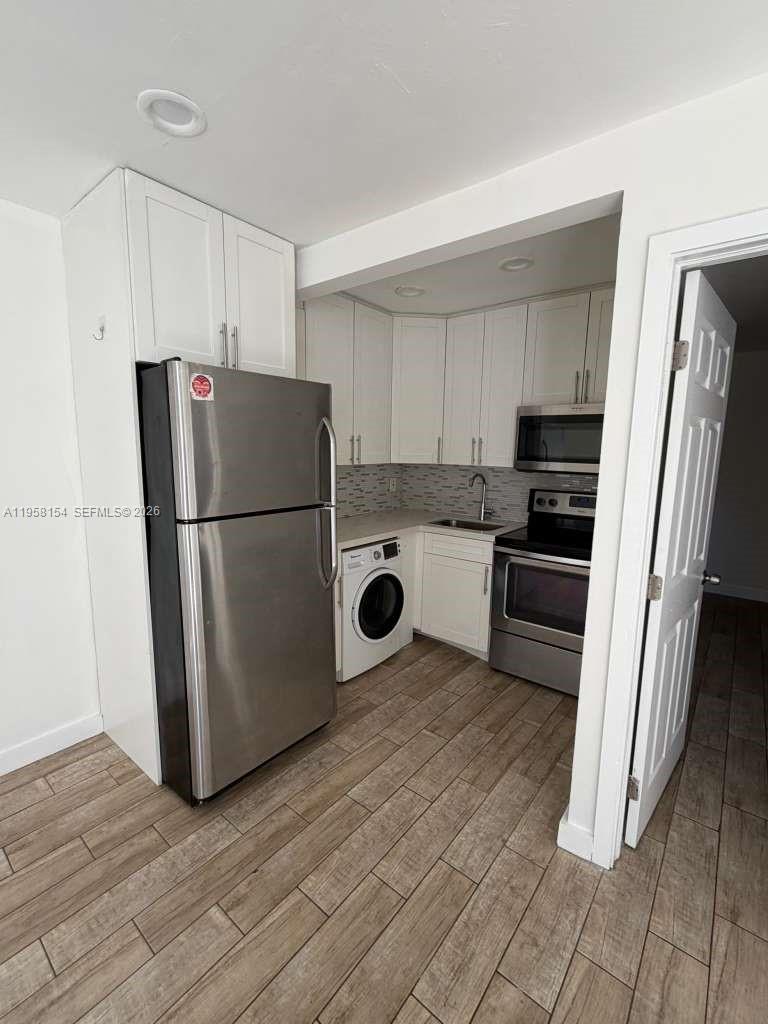 5843 Harding Street, Unit 12 Hollywood, FL 33021 - Photo 2 of 6 a kitchen with a refrigerator a stove top oven and cabinets