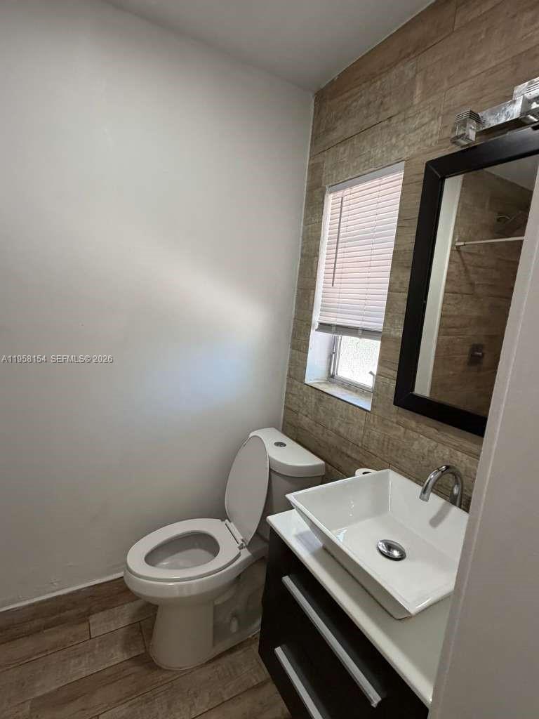 5843 Harding Street, Unit 12 Hollywood, FL 33021 - Photo 4 of 6 a bathroom with a toilet a sink and a mirror