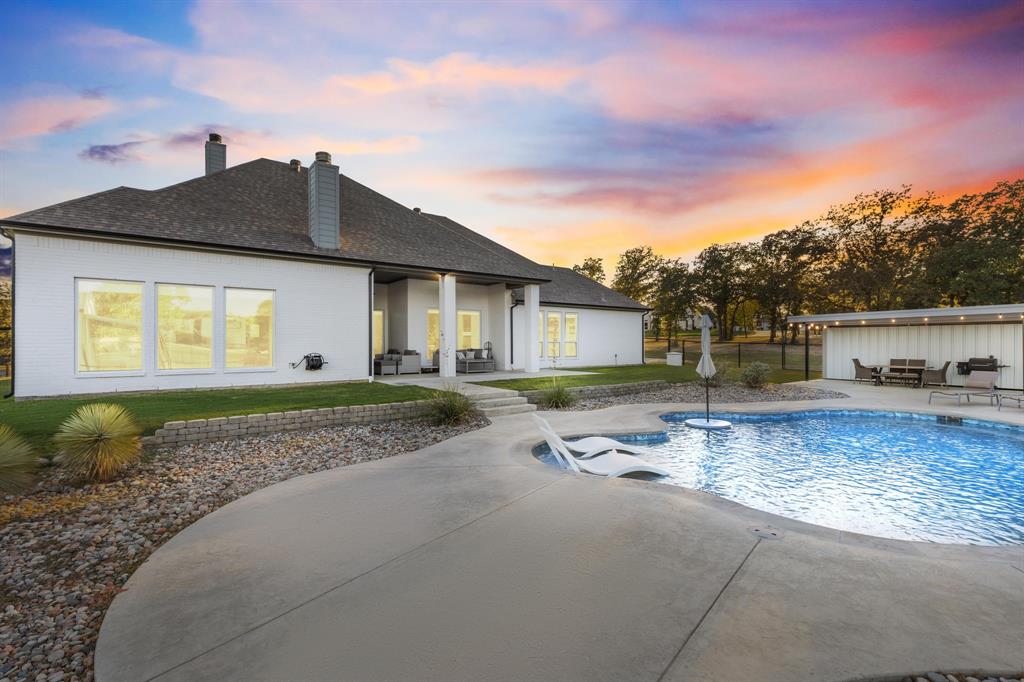 2024 Antler Loop Poolville, TX 76487 - Photo 3 of 40 Showcasing the covered back patio, over looking the pool and pool house.