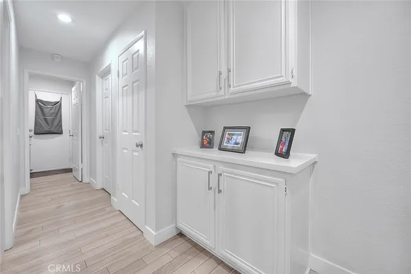 a kitchen with cabinets wooden floor and stainless steel appliances