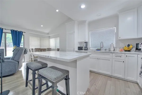 a kitchen with a stove a refrigerator a sink dishwasher with a dining table and chairs