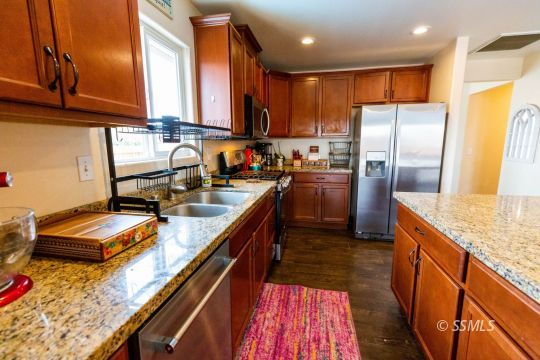 913 South McCall Street Ridgecrest, CA 93555 - Photo 6 of 40 a kitchen with kitchen island granite countertop a sink stove refrigerator and cabinets