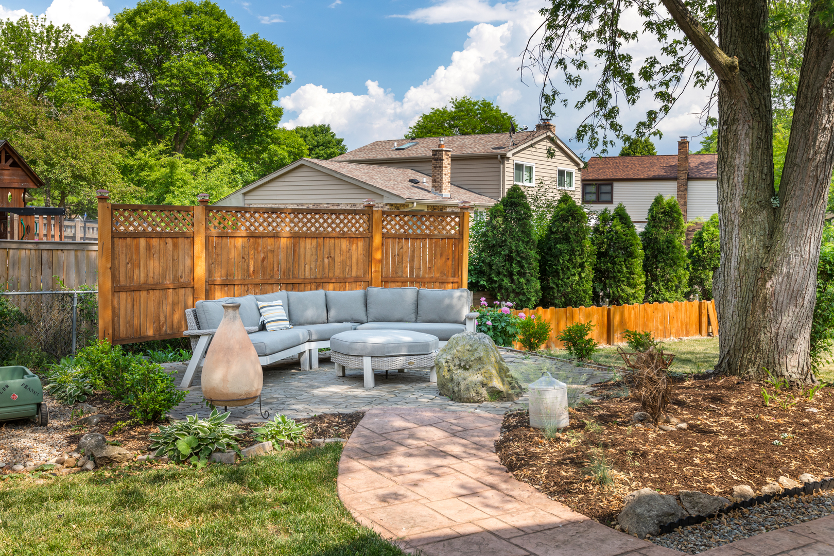 1616 Apache Drive Naperville, IL 60563 - Photo 29 of 36 a view of a backyard with couches table and chairs under an umbrella with large trees